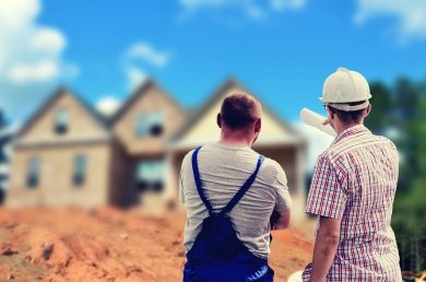 Ein Handwerker und ein Planer tauschen sich zum zu errichtenden Gebäude aus