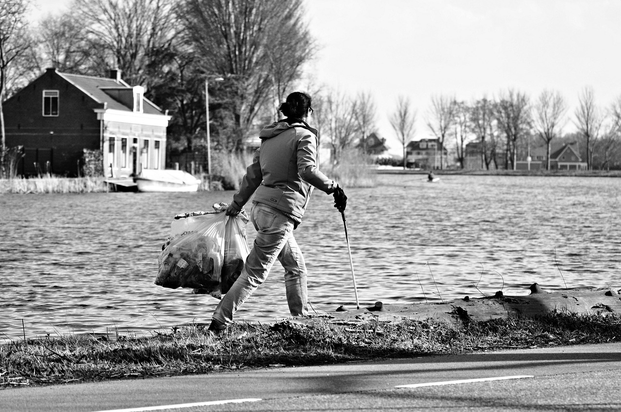 Person sammelt an Straßenrand Müll